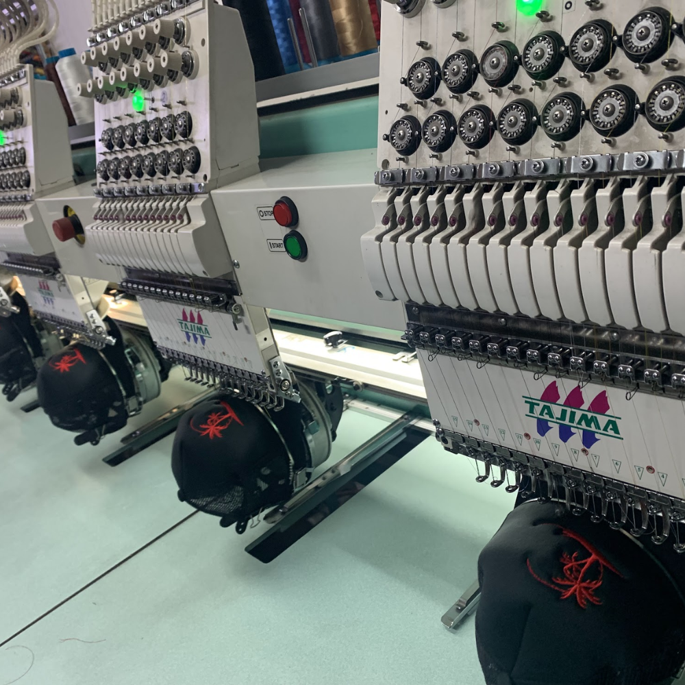Multi-head embroidery machines stitching caps on a production line