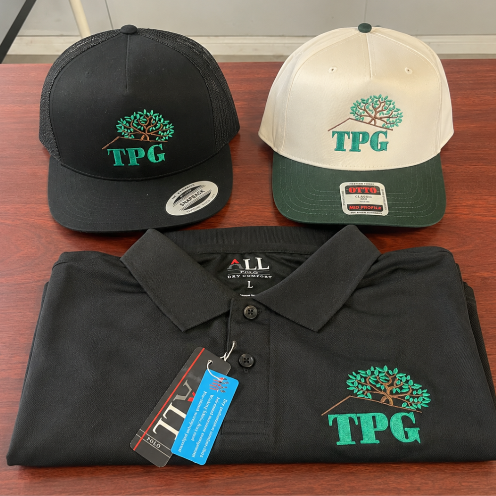 Custom embroidered TPG caps and polo shirt displayed together